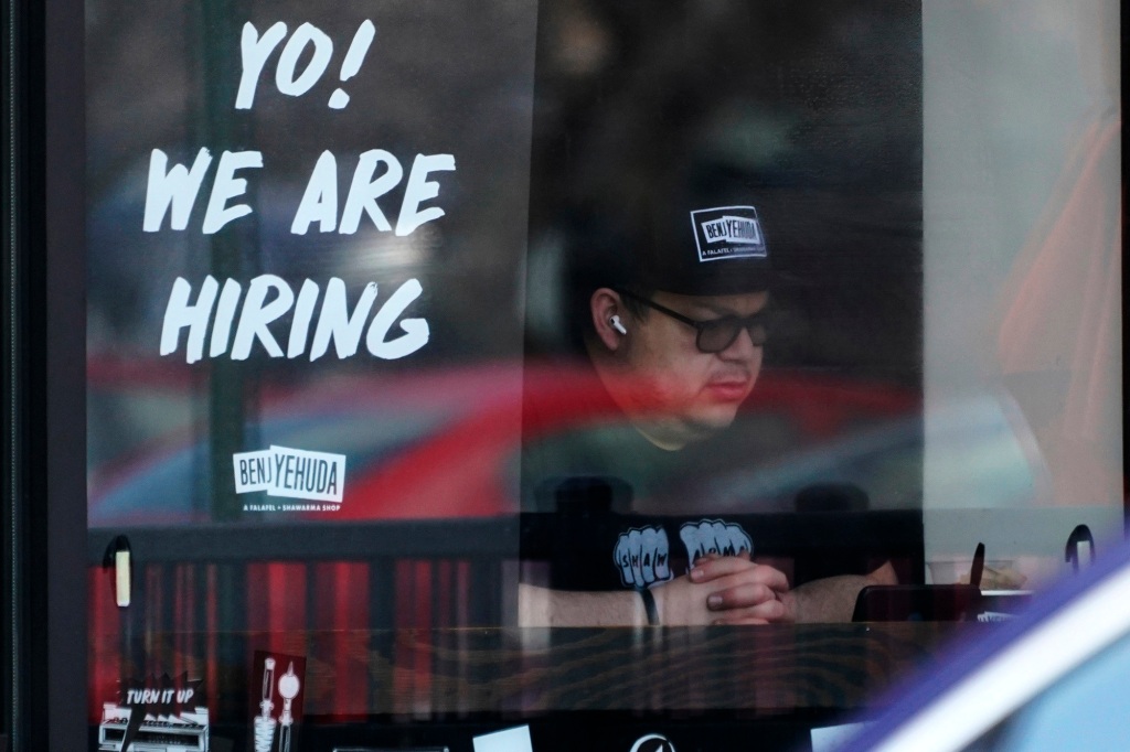 A recruitment banner is displayed at a restaurant in Schaumburg, Illinois.
