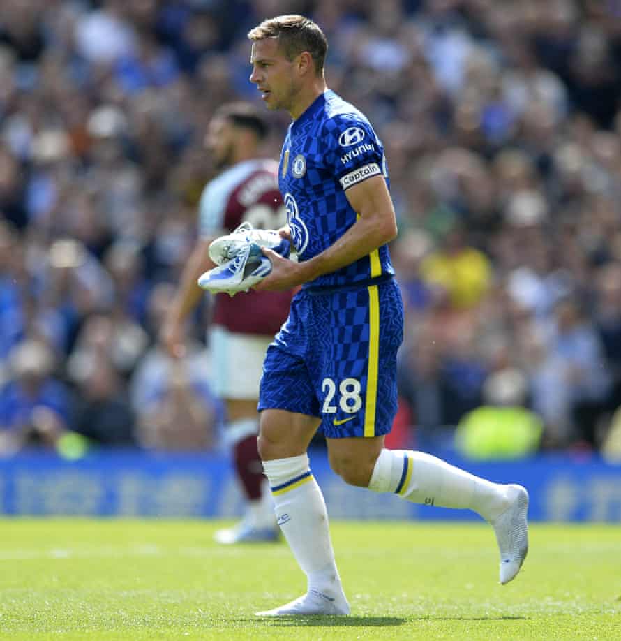 Chelsea player Cesar Azpilicueta takes off his shoes to change them.
