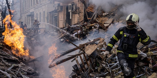 Responders are seen at the scene after a building was destroyed in a Russian missile attack in the city center of Kharkiv