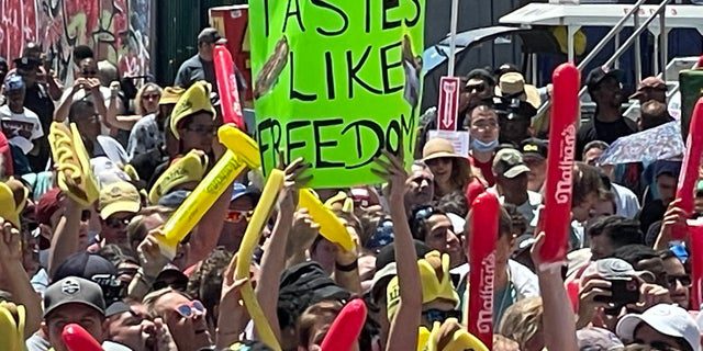 A person holding a sign that reads "Tastes like freedom" During Nathan's Famous Hot Dog Contest in Coney Island on July 4, 2022.