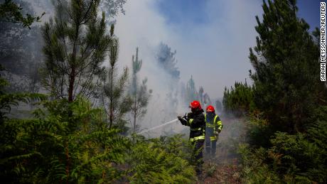 Firefighters work to contain a fire near Louchats, France, where the national weather agency has issued alerts about rising temperatures. 