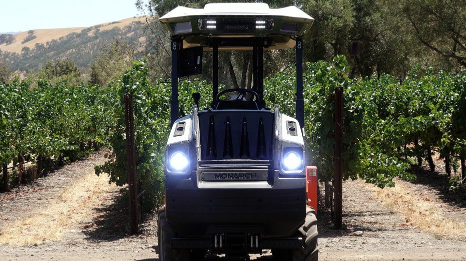 A self-driving tractor plows on a vineyard near central California.