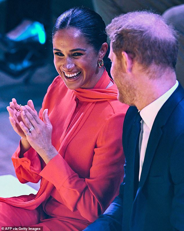 Meghan Markle interacts as she listens to Prince Harry during the annual One Young World Summit at Bridgewater Hall in Manchester