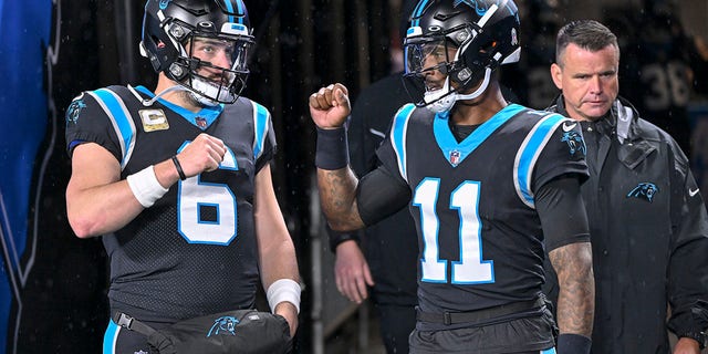 Baker Mayfield, #6 of the Carolina Panthers, and BJ Walker, #11 of the Carolina Panthers, speak before their game against the Atlanta Falcons at Bank of America Stadium on November 10, 2022 in Charlotte, North Carolina. 